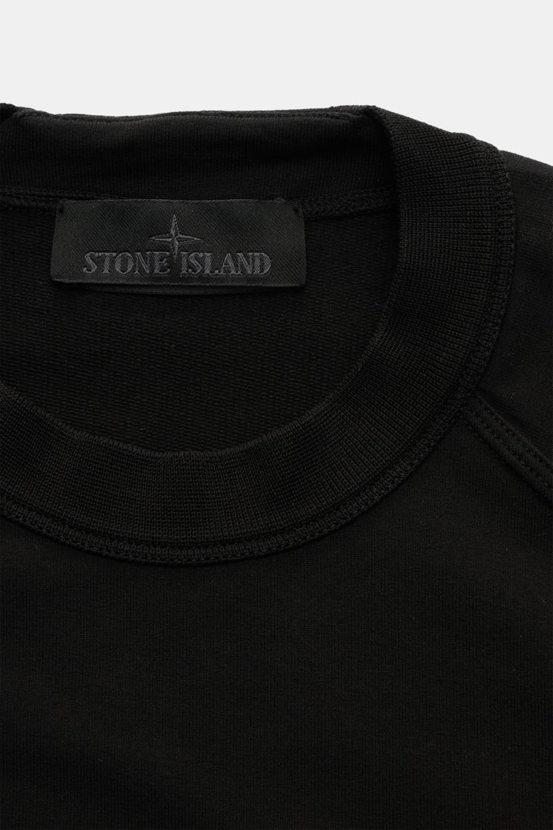 Stone Island Sweatshirt 'Ghost Piece' schwarz, Detailansicht von oben, Rundhalsausschnitt, elastische Baumwolle, tonales Kompass-Badge am Ärmel, Regular Fit.