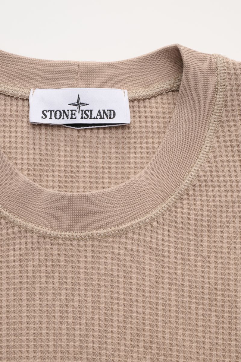 Close-up front view of Stone Island Rundhalspullover 'Waffle' taupe with waffle knit texture and ribbed round neckline.

Basic Piece mit Twist: Dieser Pullover im Waffelstrick von STONE ISLAND wird zur idealen Grundlage moderner Freizeitlooks und lässt