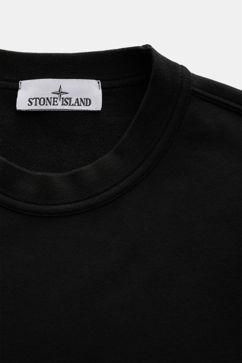 Close-up front view of the black Stone Island Rundhals-Sweatshirt 'Seasonal Pocket' schwarz showing the round neckline and label.

Zeitloses Basic Piece: Das sportive Sweatshirt von STONE ISLAND wird zur idealen Grundlage legerer Freizeitlooks und avan
