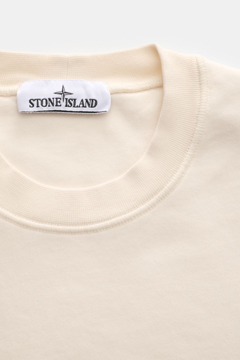 Stone Island Rundhals-Sweatshirt 'Basic Sweat' creme, Nahaufnahme von oben, weicher Baumwollstoff, Rippbündchen, Kompass-Badge am Oberarm, Regular Fit.