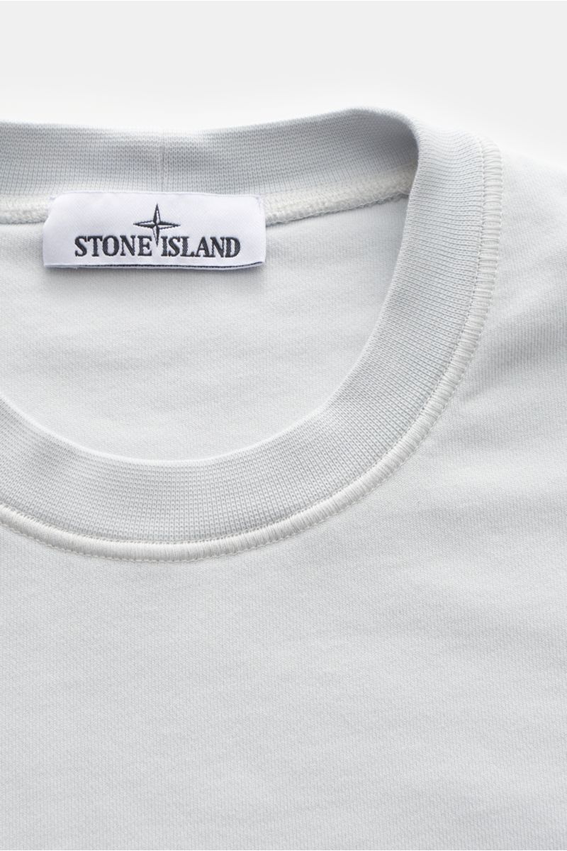 Close-up front view of Stone Island Rundhals-Sweatshirt 'Basic Sweat' pastellblau, showing round neckline and Stone Island label.

Zeitloses Basic Piece: Das sportive Sweatshirt von STONE ISLAND wird zur idealen Grundlage legerer Freizeitlooks und avan
