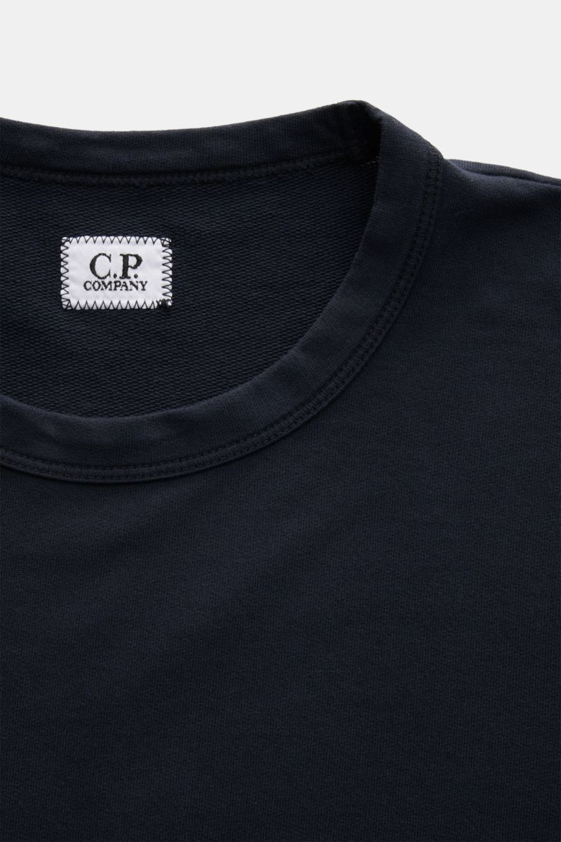 Close-up front view of C.P. Company Sweatshirt navy showing the round neckline, pure cotton fabric, and stitched brand label inside collar. 