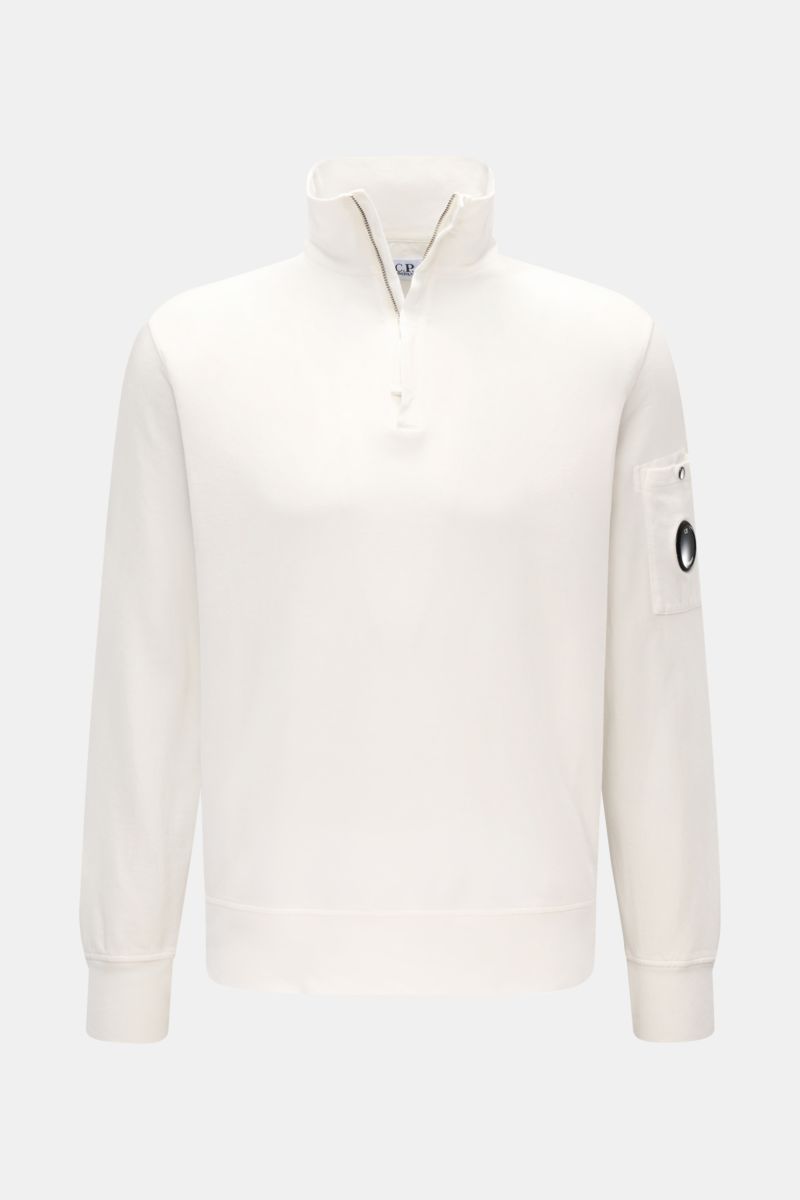 Front view of C.P. Company Sweat-Troyer offwhite, a lightweight, pure cotton sweatshirt with a zip-up troyer collar, arm pocket, and signature lens detail. Schon auf den ersten Blick spürt man die sportive DNA: Das innovative Casualwear-Label C.P. COMPANY