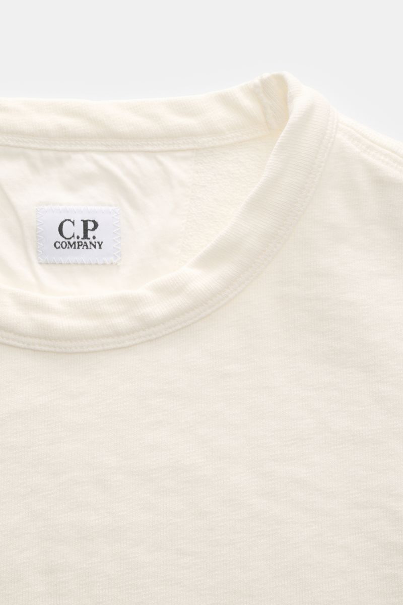 Nahaufnahme des Kragens und des C.P. Company Rundhals-Sweatshirts creme, gewaschen, mit feiner Naht und weichem Baumwollstoff.