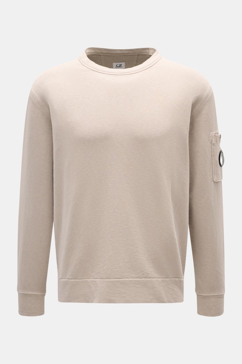 C.P. Company Rundhals-Sweatshirt beige shown from the front, made of garment-dyed pure cotton with a round neck, arm pocket, and ribbed cuffs. 