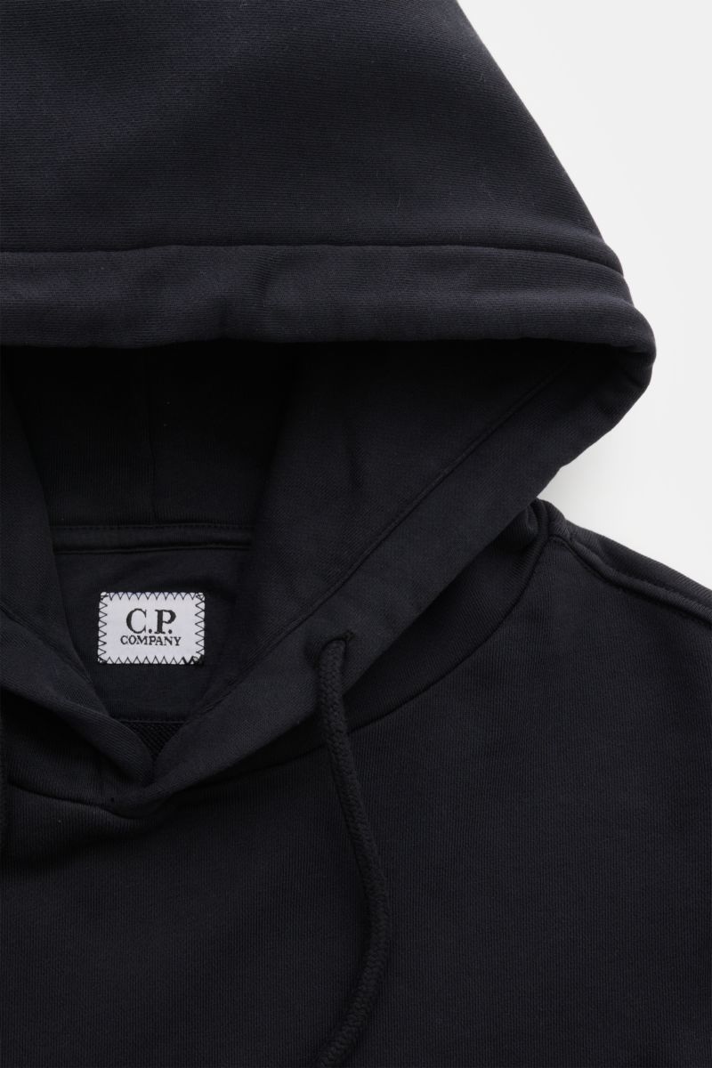 Close-up front top view of C.P. Company Hooded jumper navy in pure cotton, showing the hood with drawstring and visible brand label inside.