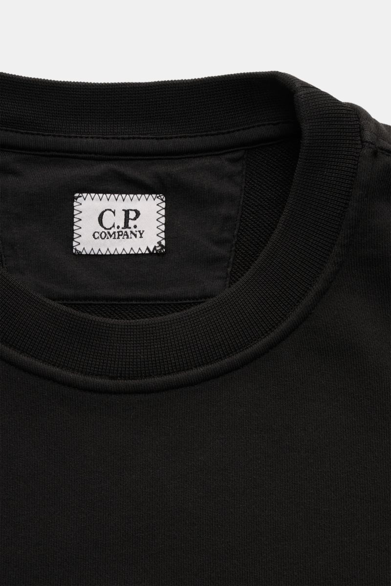 C.P. Company Sweatshirt schwarz, Nahaufnahme von Rundhalsausschnitt und Innenschild, aus leichter reiner Baumwolle gefertigt.