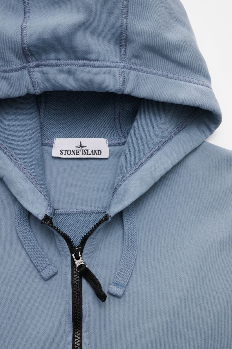 Close-up front view of Stone Island Sweat jacket smoky blue, showing the hood, drawstrings, robust black zipper, and label.

A relaxed basic from STONE ISLAND: This piece-dyed sweat jacket with a practical hood made of pure cotton is perfect for sport 
