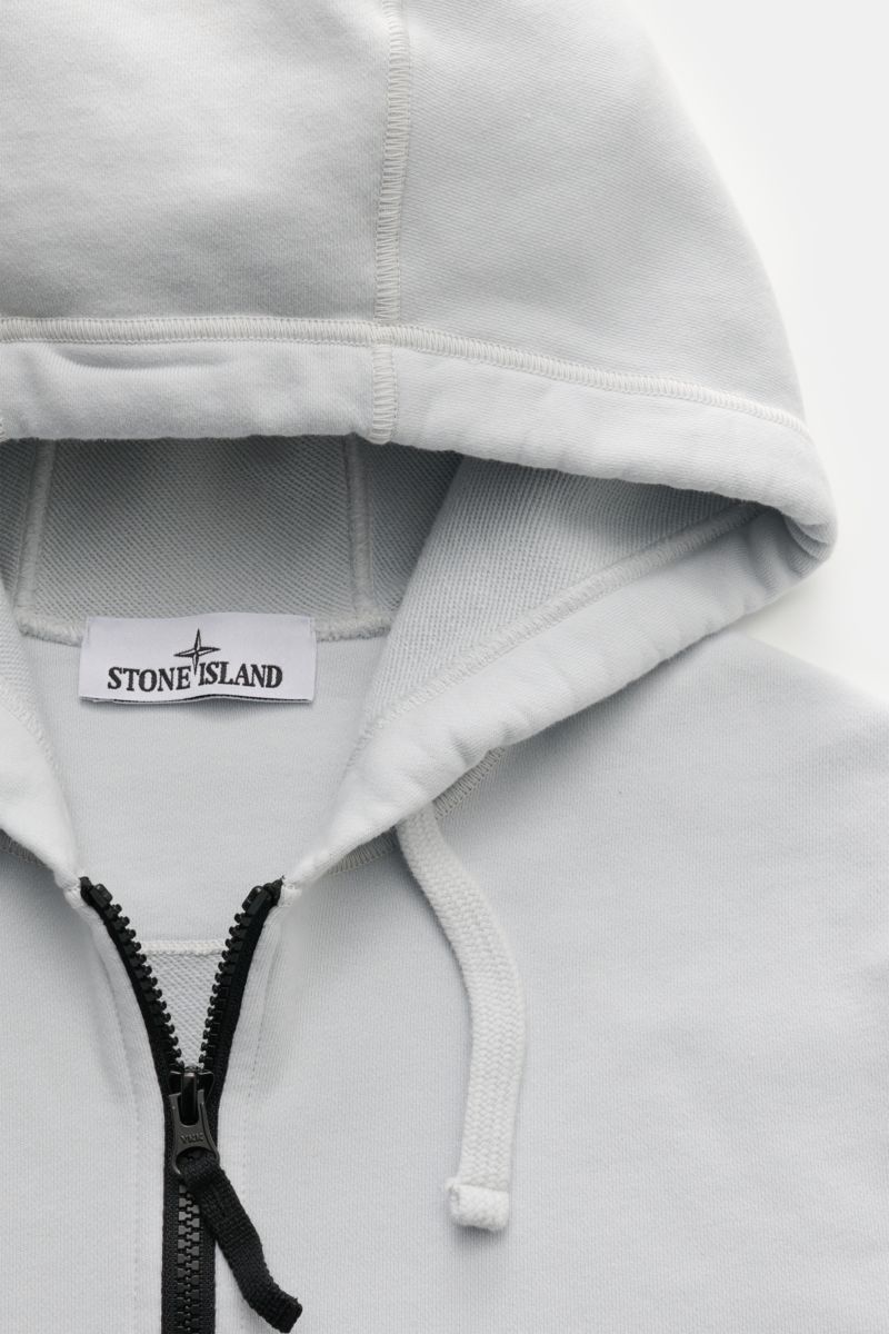 Stone Island Sweatjacke hellgrau, sportiver Regular Fit, Kapuze mit Kordel, robuster Reißverschluss, weicher Baumwoll-Sweat, Nahaufnahme von oben.