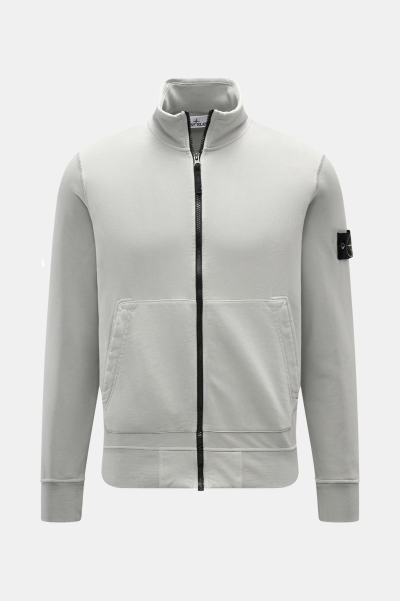 Front view of Stone Island Sweatjacke hellgrau, a light grey garment dyed cotton sweatshirt with a soft touch, regular fit, robust zipper, high stand collar, split kangaroo pocket, compass badge on sleeve, and ribbed cuffs.

Entspanntes Basic von STONE