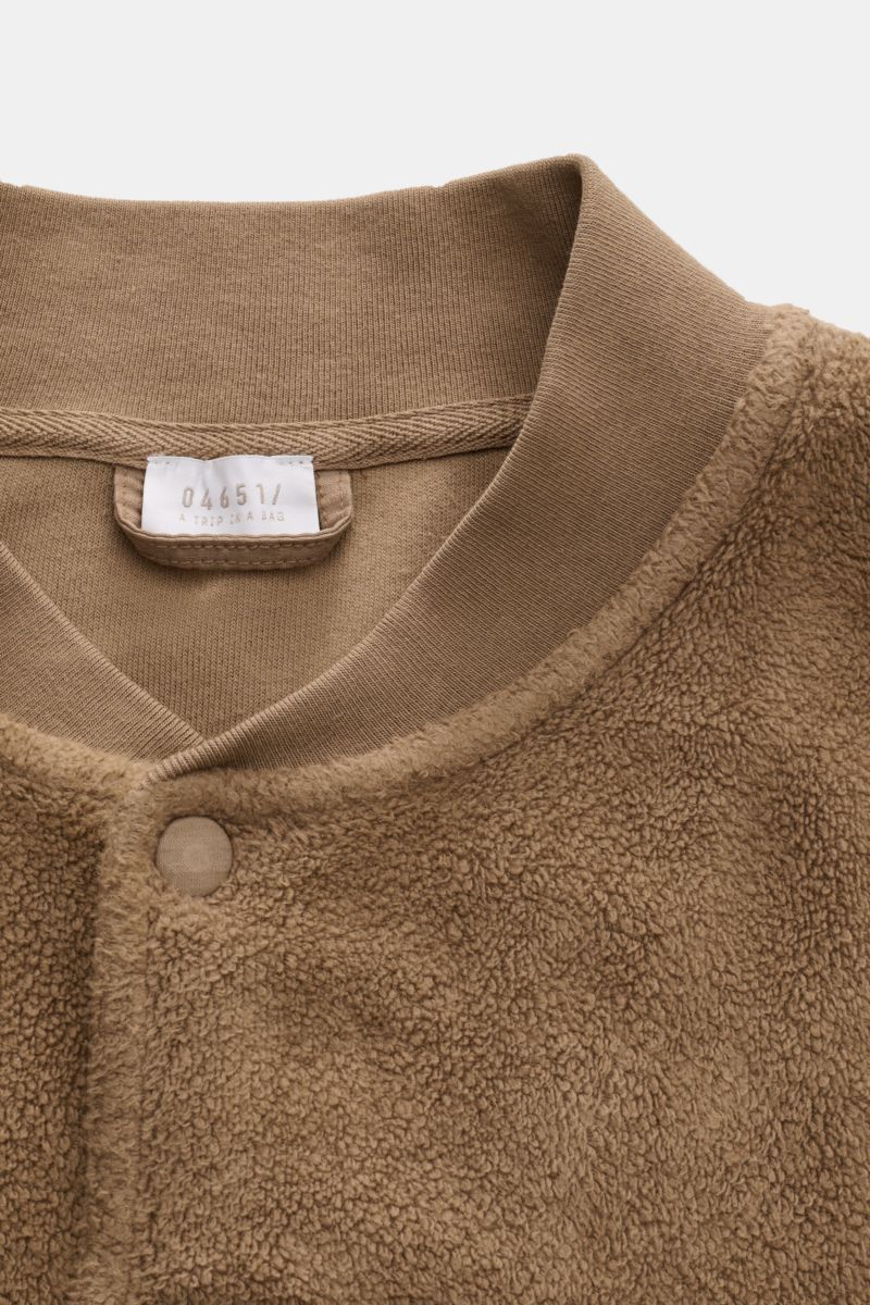 Close-up front view of 04651/ A trip in a bag Fleece blouson taupe showing pure cotton fleece, soft feel, slim fit, snap button placket, signature blouson collar in rib knit, angled hip pockets, comfortable ribbed bands, and woven label in the side seam.