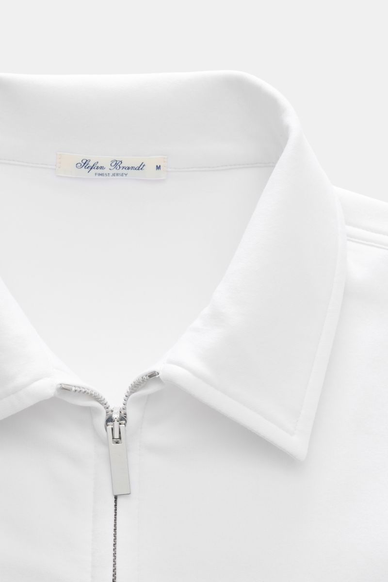Close-up front view of Stefan Brandt Sweatjacke 'Alek' weiß featuring a silver two-way zipper, turn-down collar, and soft white Pima cotton fabric. Spürbarer Komfort auf höchstem Niveau: Selbst ein Essential wie die Sweatjacke 'Alek' wird bei STEFAN BRAND