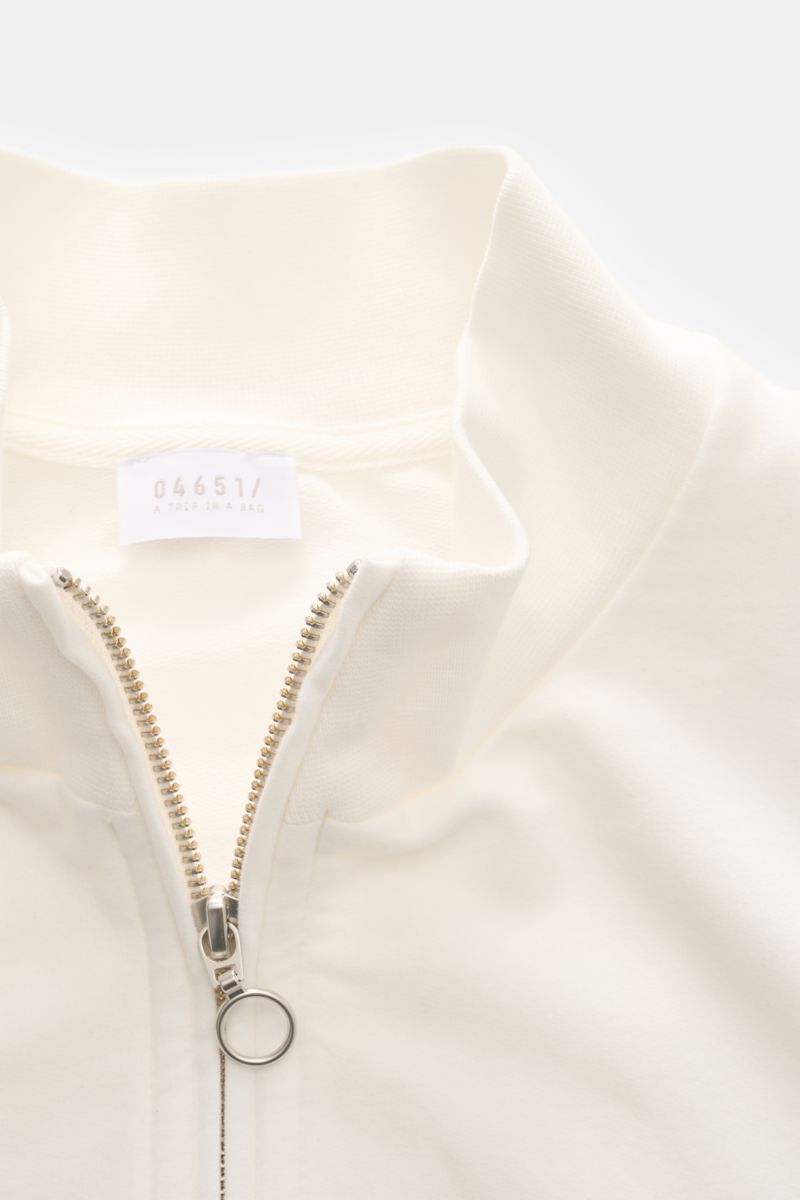 Close-up front view of 04651/ A trip in a bag Sweat jacket 'IF Track' off-white with high collar and silver ring zip, showing soft cotton jersey fabric. Relaxation on the move: The sweat jacket 'IF Track' by 04651/ A TRIP IN A BAG is made of super soft