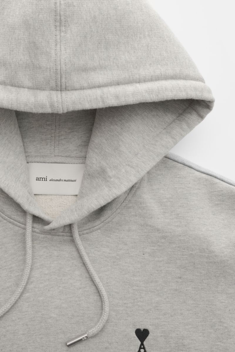 Ami Paris Kapuzenpullover grau meliert in Frontansicht mit Kapuze, Tunnelzug, Herz-Stitching und Kängurutasche aus elastischer Baumwolle.