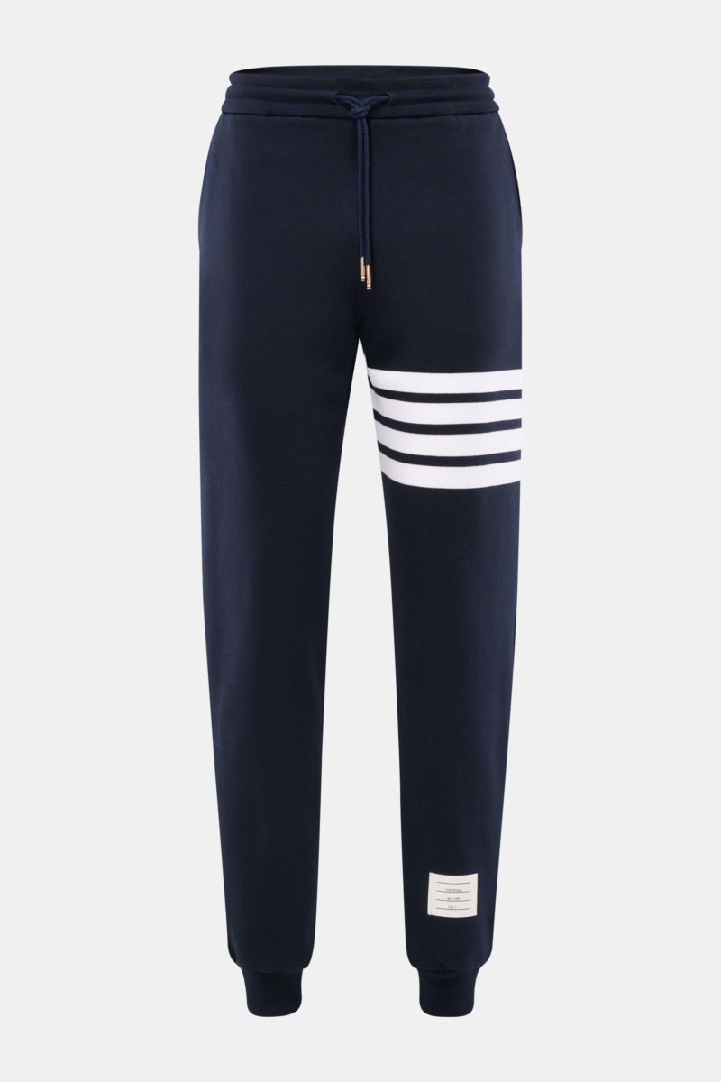 Frontansicht der Thom Browne Sweathose navy mit elastischem Bund, Tunnelzug, markentypischem weißen Streifen-Detail, slim Fit und Rippbündchen.
