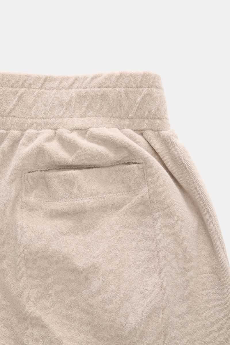 Close-up rear view of 04651/ A trip in a bag Frottee-Shorts 'Terry' beige, showcasing the elastic waistband, back welt pocket, and soft cotton terry fabric.

Description: Mit dem Modell 'Terry' präsentiert 04651/ A TRIP IN A BAG komfortable Shorts aus 