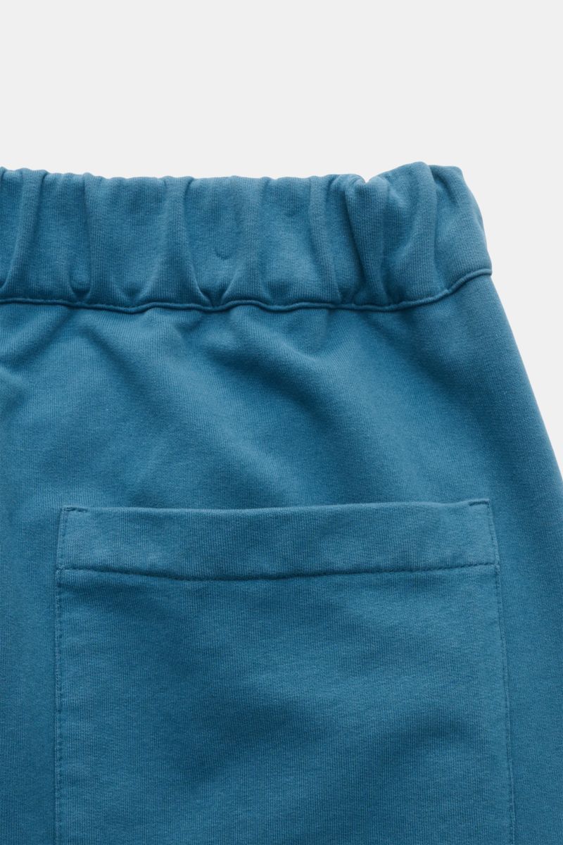 Alt tag (125 characters):
Close-up rear view of 04651/ A trip in a bag Sweat shorts teal showing elastic waistband and patch back pocket in soft cotton fabric.

Description:
Relaxation all day long: These sweat shorts by 04651/ A TRIP IN A BAG, made fr