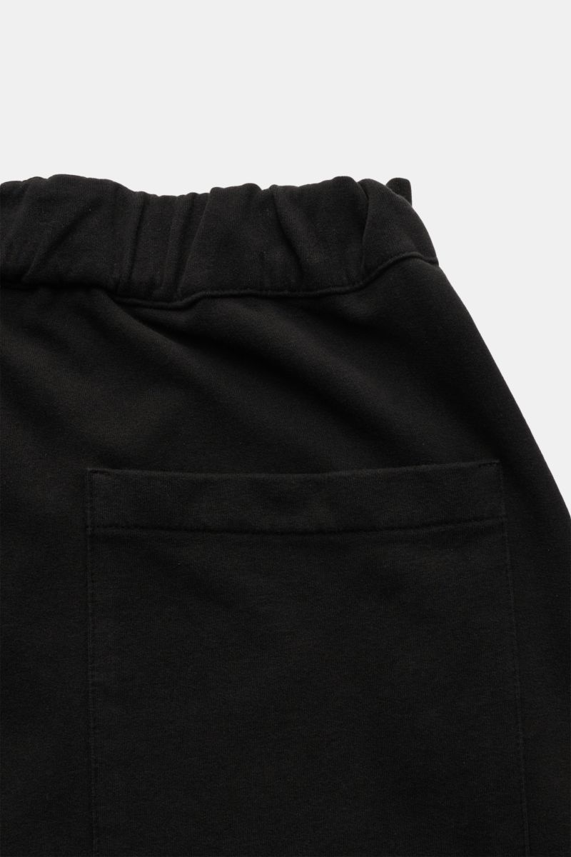 Schwarze 04651/ A trip in a bag Sweat-Shorts im Detail von hinten oben, elastischer Bund, aufgesetzte Gesäßtasche, weicher Baumwollsweat.