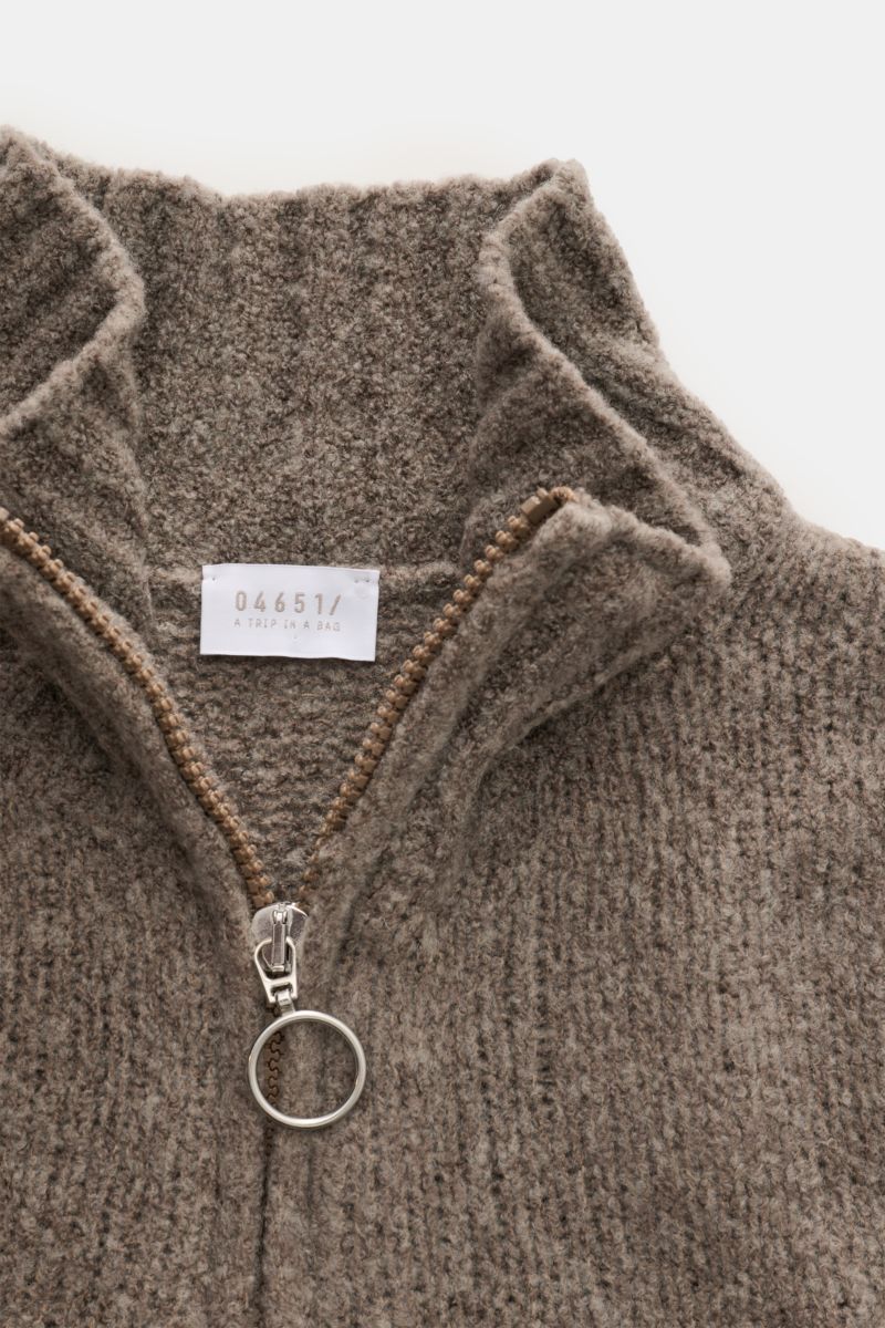 Nahaufnahme von 04651/ A trip in a bag Troyer 'Grainy' taupe, von oben fotografiert, Boucléstrick mit mittelfeinem Strickbild, Mix aus Wolle und Microfaser, weicher Griff, Regular Fit, hoher Rippstrickkragen mit Zipper und breiten Rippbündchen.