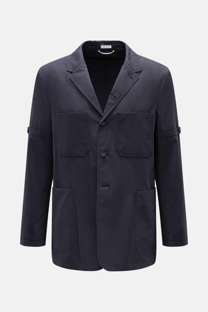 Front view of Thom Browne Jacket navy in slim fit pure cotton with four-button placket, adjustable collar, four front pockets, sleeve tabs, and waist tab.

Elegant outdoor essential: The THOM BROWNE jacket impresses with the timeless design of a smart-