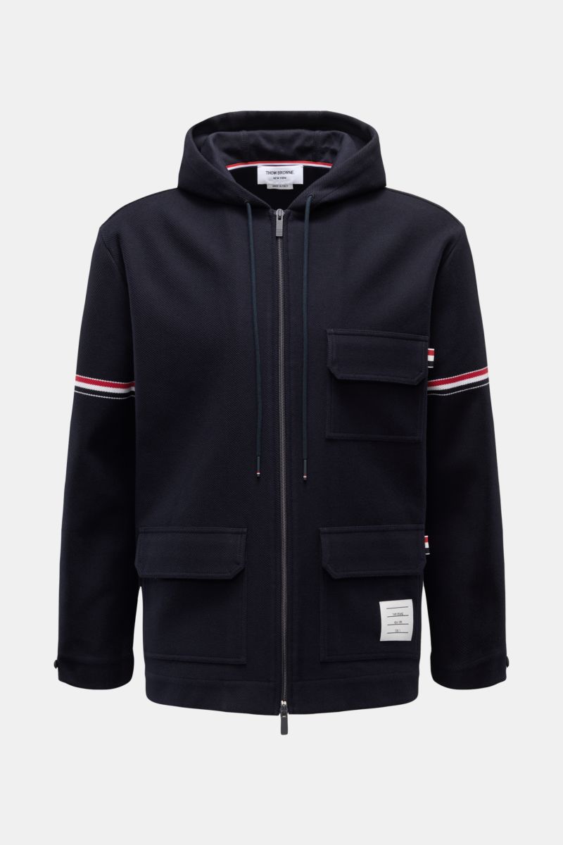 Thom Browne Jacke navy aus reiner Baumwolle mit Kapuze, Zwei-Wege-Reißverschluss, drei Taschen und Label-Streifen, frontal fotografiert.