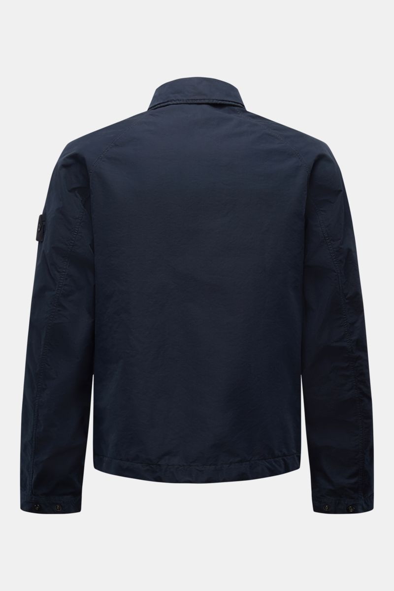 Rear view of Stone Island Jacke 'Ghost Piece' navy, a slim fit jacket with high-quality garment dyed microfiber, soft touch, snap button placket, turn-down collar with button tab, flap front pockets, tonal compass badge on upper arm, and snap button cuffs
