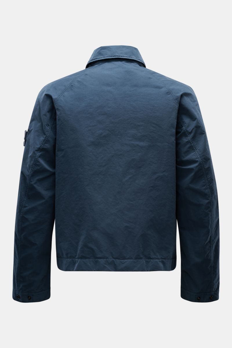 Stone Island Jacke 'Ghost Piece' dunkelblau shown from the back, made of high-quality microfiber with a soft touch, slim fit, featuring a snap button placket, turn-down collar with button tab, flap front pockets, tonal compass badge on the upper arm, and 