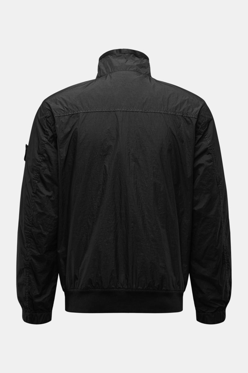 Rear view of Stone Island Blouson 'Garment Dyed Crinkle Reps NY' schwarz in black, lightweight microfiber with resin coating, slim fit, elastic cuffs and hem, standing collar, and compass badge on the sleeve. Funktion trifft Style: Der legere Blouson von 
