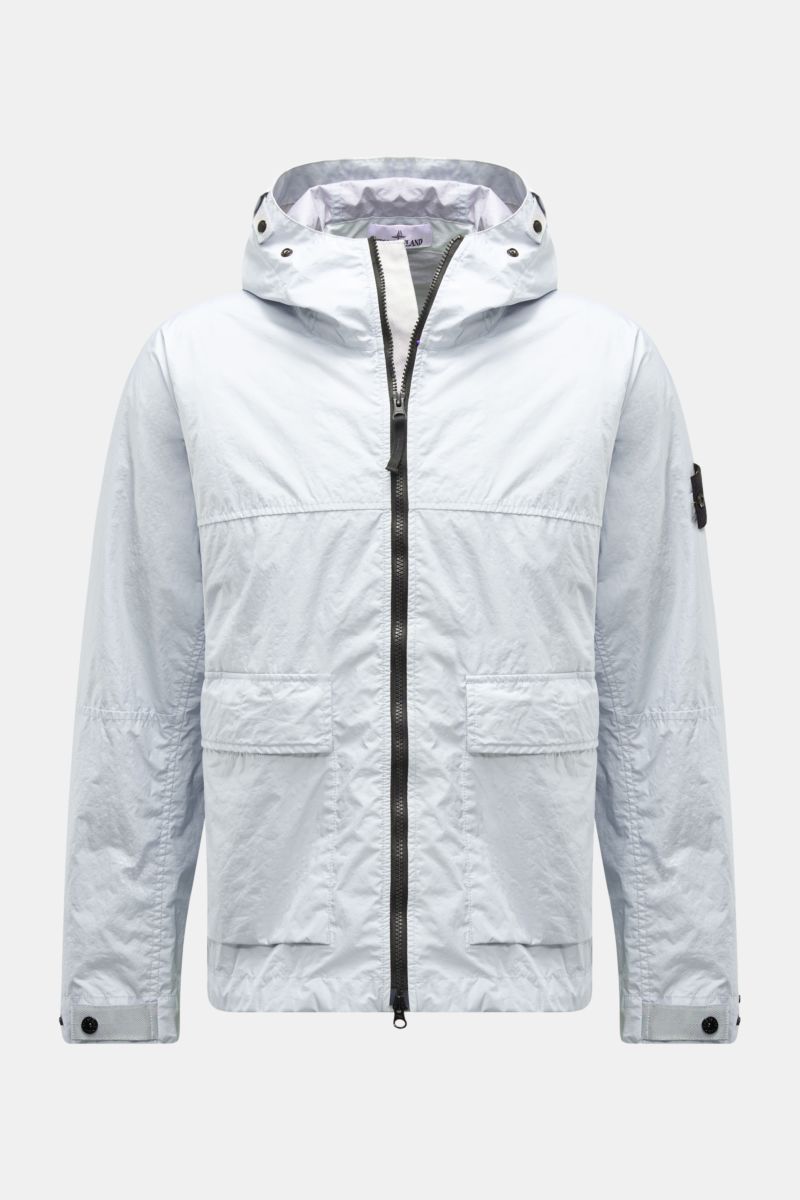 Front view of Stone Island Jacke 'Membrana' hellgrau, a light grey, wind- and water-resistant jacket with hood, two-way zipper, flap pockets, button cuffs, and compass badge on sleeve.