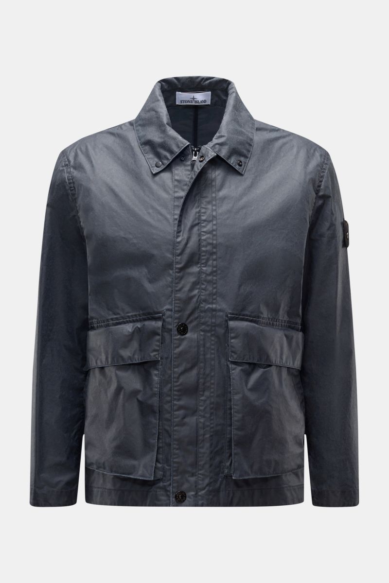 Front view of Stone Island Waxed jacket 'Waxed Pigment Cotton Tela' navy, featuring a waxed, water-repellent cotton-polyester canvas with adjustable collar and cuffs, robust two-way zip, storm flap, button flap pockets, and signature compass badge on the 