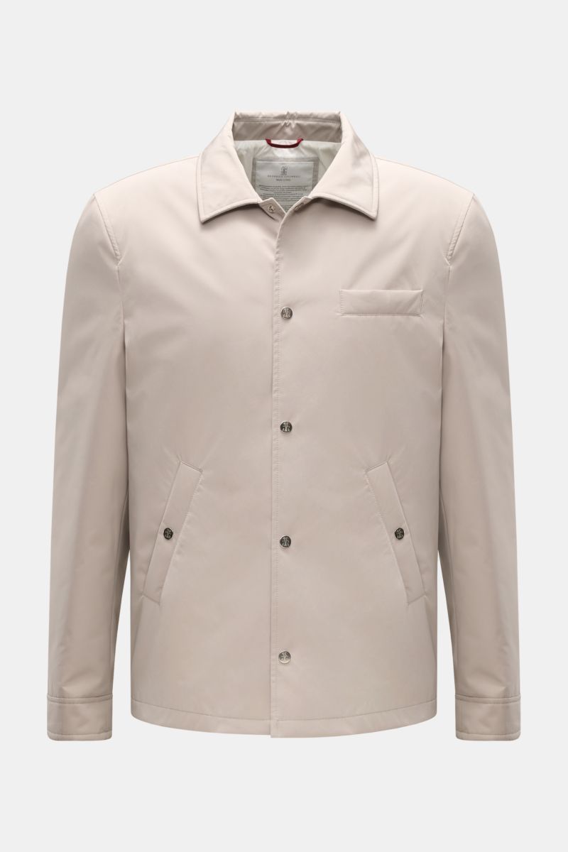 Front view of the Brunello Cucinelli Jacke sand, a sand-colored jacket made of high-quality microfiber with a soft, smooth touch, featuring a regular fit, snap-button placket, turn-down collar, classic chest pocket, angled hip pockets with snap buttons, s