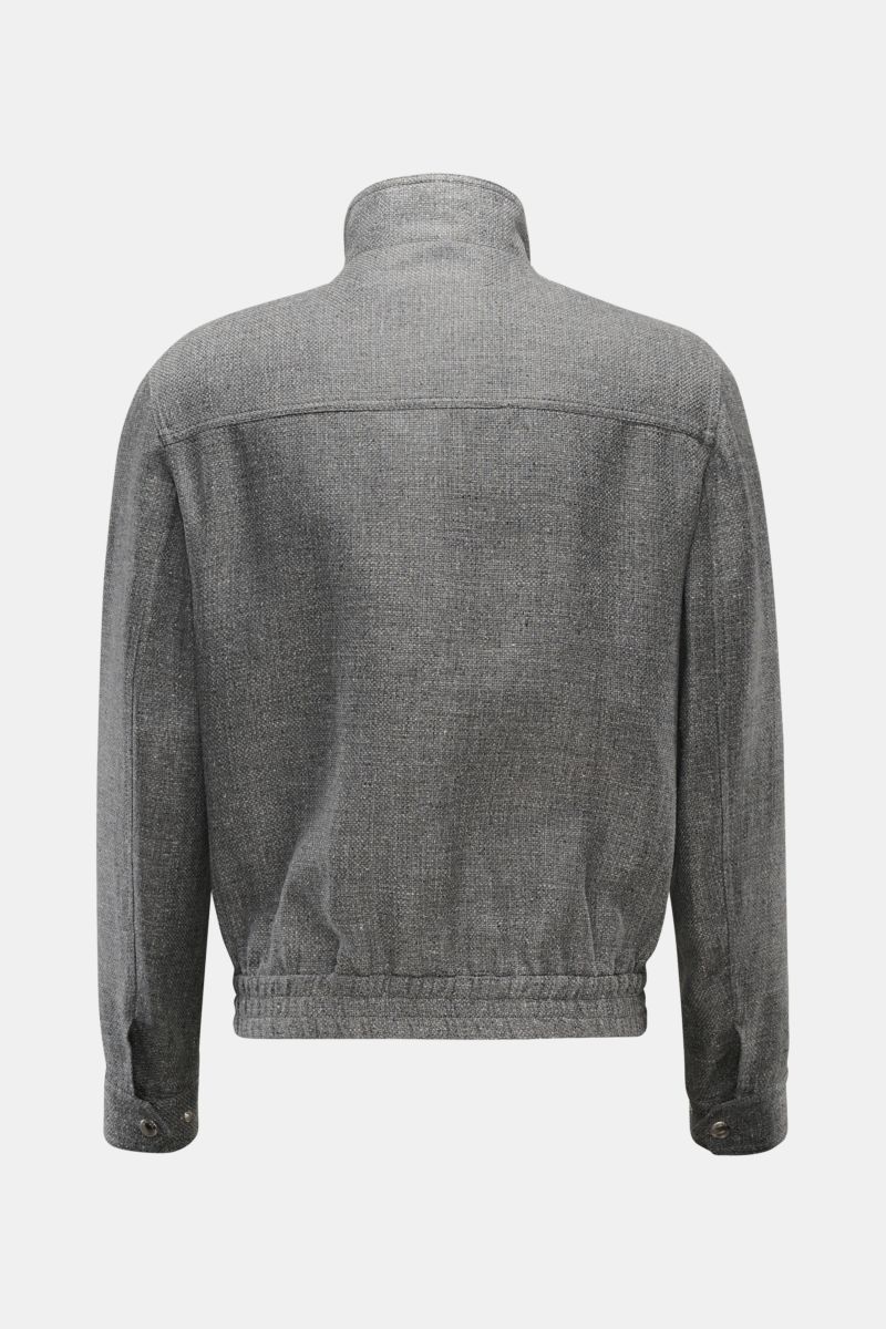 Back view of the Brunello Cucinelli Blouson sand meliert, a lightweight jacket with a slim fit, high collar, elastic hem, and buttoned cuffs. Luxus in jedem Detail: Von der Wahl des Mischgewebes aus Leinen und Wolle mit einem Anteil von Seide bis hin z