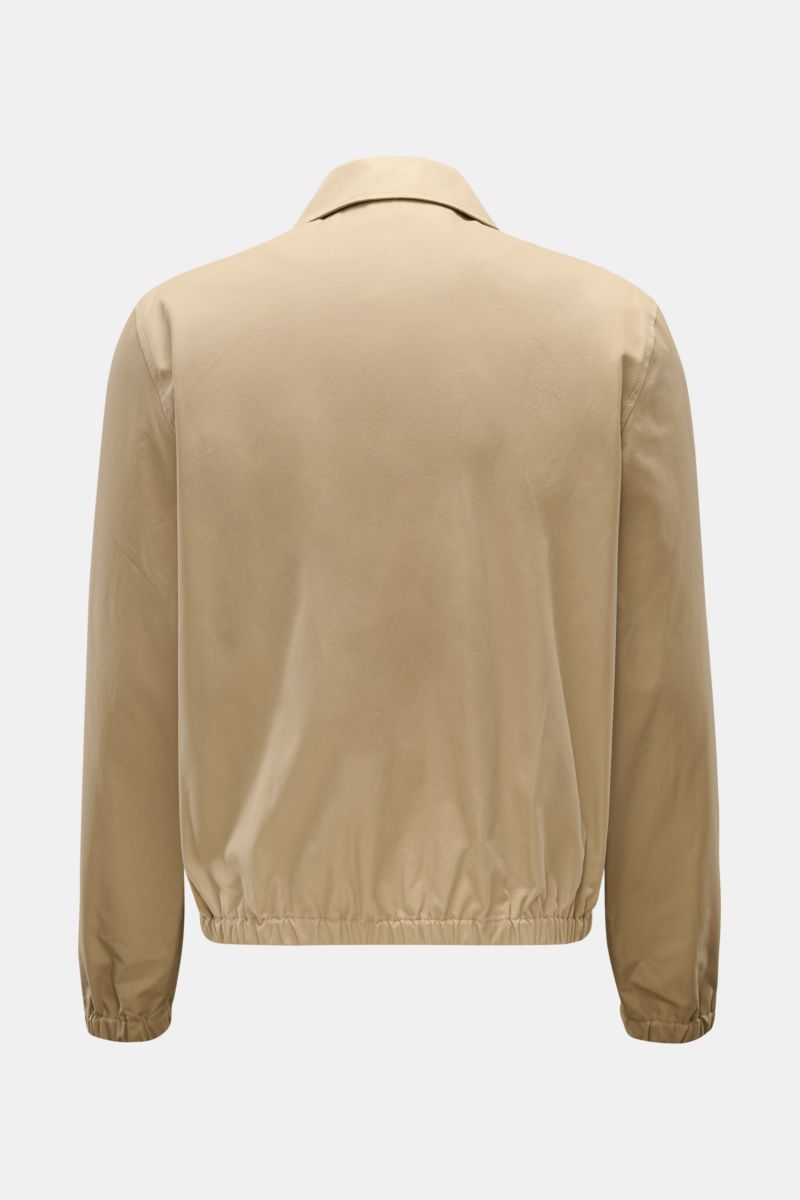 Rear view of Ami Paris Blouson taupe in pure cotton with soft touch, elastic cuffs and hem, showing slim fit and collar. Stylish transitional jacket with two-way zipper, slanted welt pockets, logo stitching on chest, and inner pocket.