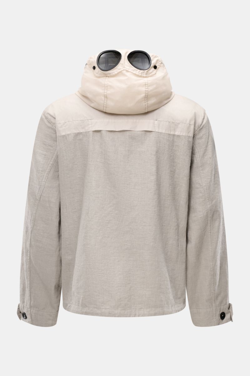 Back view of C.P. Company Jacket 'Goggle Jacket' grey, showing detachable hood with integrated goggle lenses, textured microfibre, regular fit.

Description: Signature design from C.P. COMPANY: The 'Goggle Jacket' makes a futuristic statement with its 