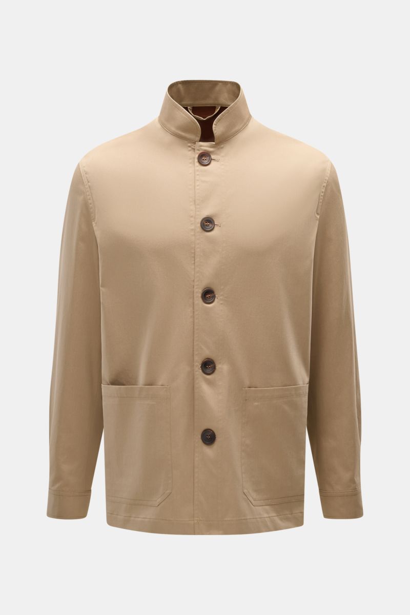 Front view of the Doppiaa Overshirt 'Aasti' beige, a lightweight cotton shirt with a standing collar and five-button placket, patch hip pockets, and button cuffs. Versatile style for spring and summer: The subtle workwear charm of the lightweight cotton '