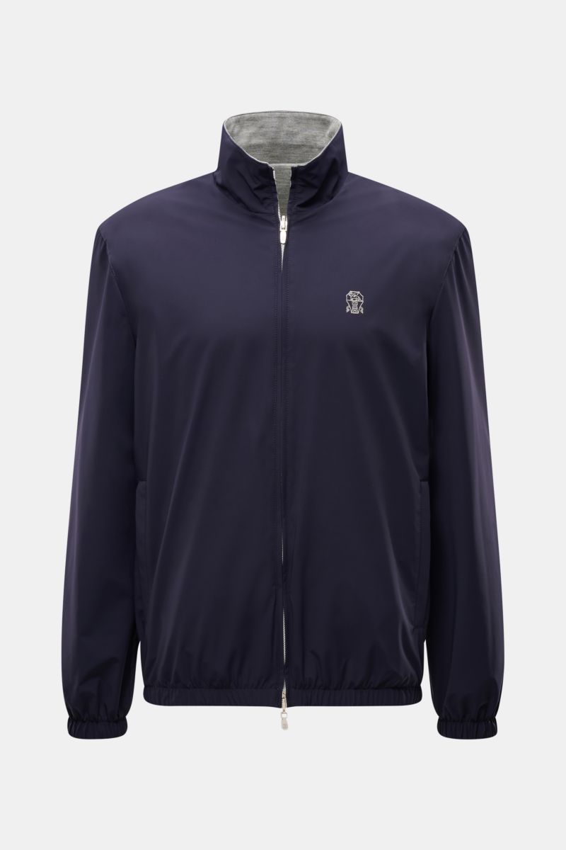 Brunello Cucinelli Wendeblouson navy/grau front view, navy wind- and water-repellent microfibre jacket with stand-up collar, elastic cuffs and hem, reversible with grey cashmere-silk jersey inside, logo stitching on front. 

Zwei Looks, ein Anspruch: B