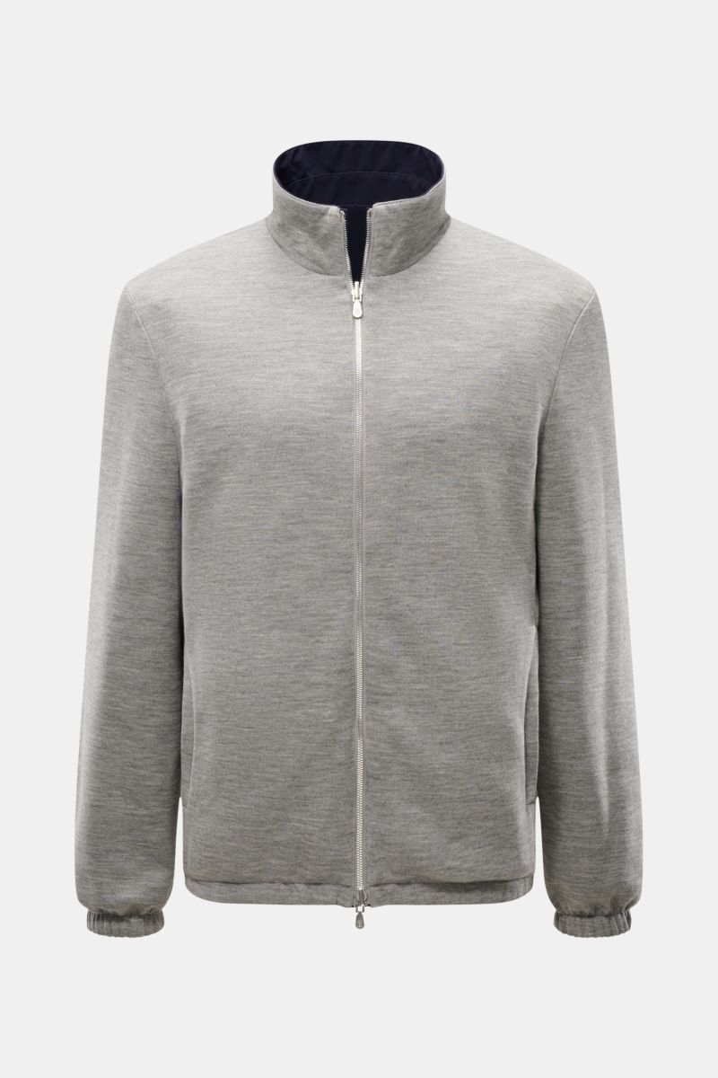 Front view of the Brunello Cucinelli Wendeblouson navy/grau, a reversible jacket with a high collar and zipper, shown in grey with navy interior.

Zwei Looks, ein Anspruch: BRUNELLO CUCINELLI präsentiert mit diesem wind- und wasserabweisenden Blouson e