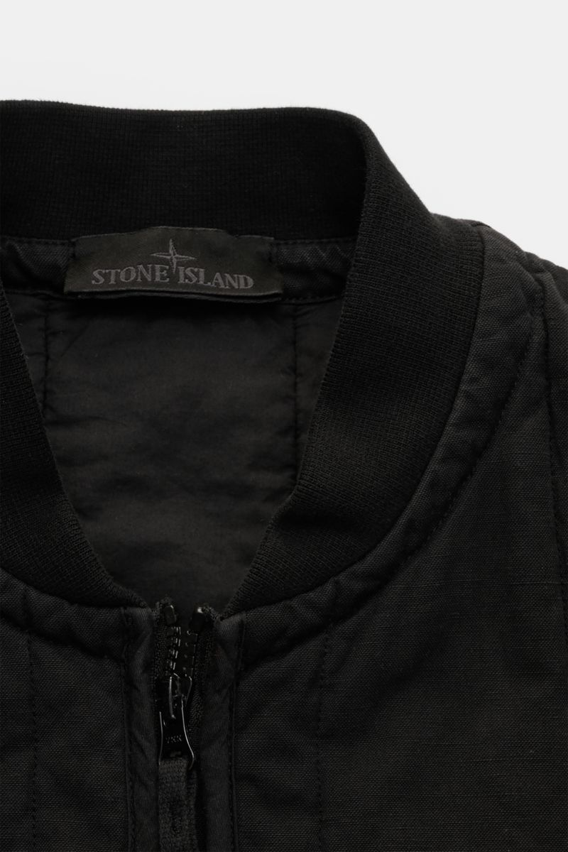Stone Island Outdoorweste 'Ghost Piece' schwarz, Slim Fit, Baumwolle-Leinen-Mix, Blousonkragen, Zweifach-Reißverschluss, Nahaufnahme von oben.