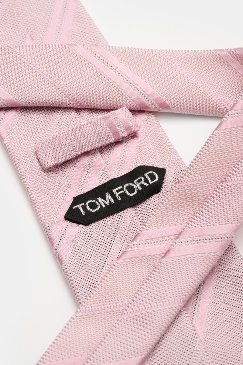 Close-up of the Tom Ford Seidenkrawatte altrosa/weiß gestreift showing its fine silk weave, subtle shine, and branded lining from a top-down perspective.

Description: Italienische Handwerkskunst: Dieser Krawatten-Klassiker von TOM FORD aus reiner Seid