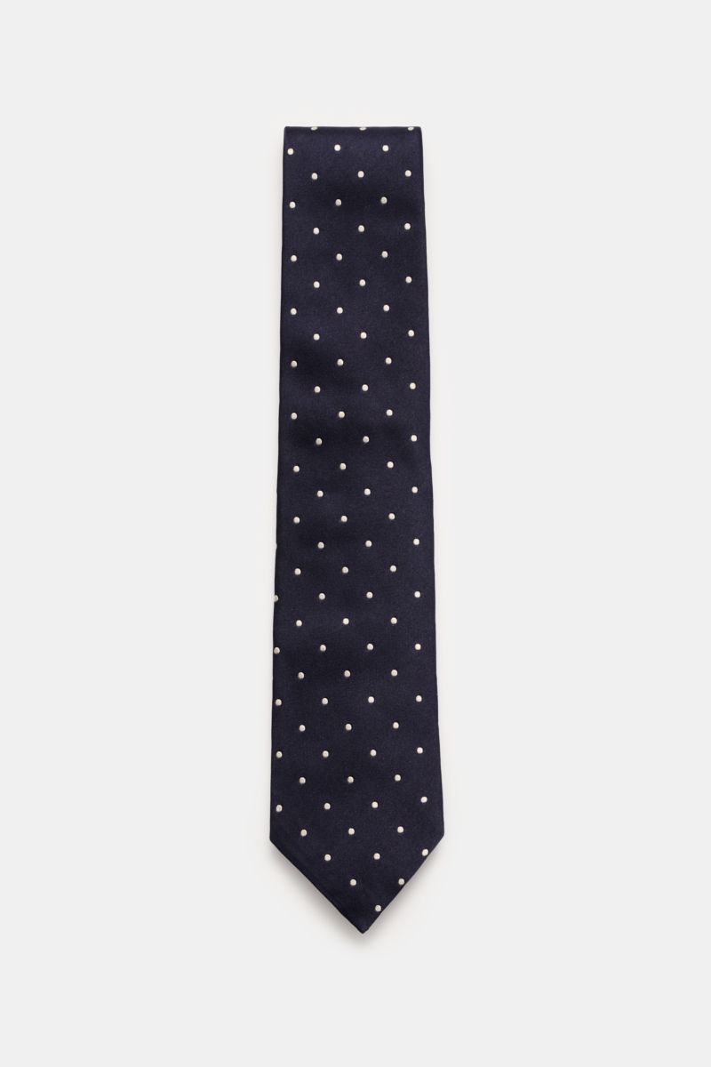 Top-down view of the Tom Ford Seidenkrawatte navy/creme gepunktet silk tie with white polka dots on navy background.

Description: Zeitloser Stil mit luxuriöser Note: Die Seidenkrawatte von TOM FORD überzeugt als elegantes Essential für formelle Anläss