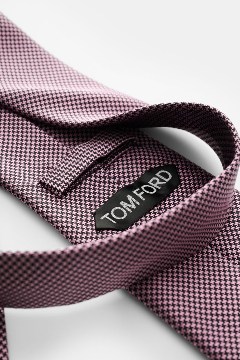 Tom Ford Seidenkrawatte rosé/schwarz gemustert mit Hahnentritt, Logo-Stitching, reine Seide, dezenter Glanz, seitliche Nahaufnahme.