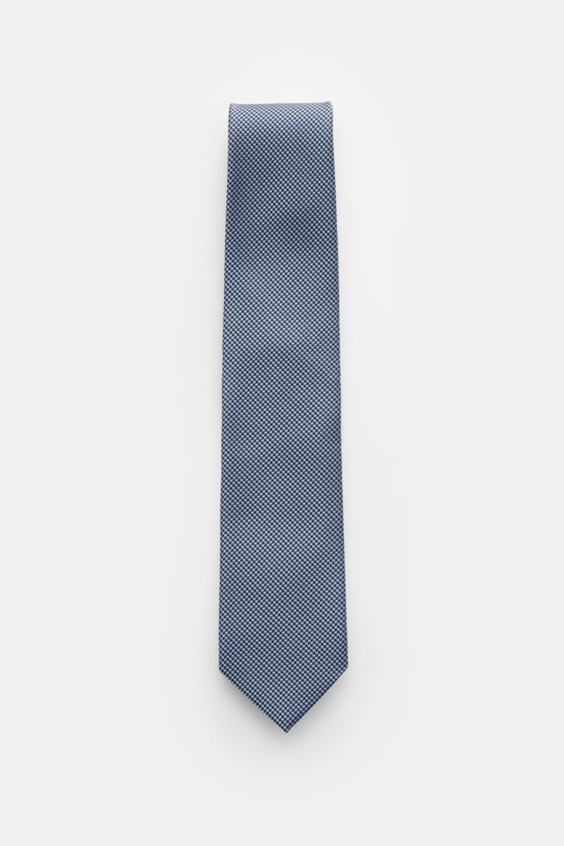 Tom Ford Seidenkrawatte hellblau/schwarz gemustert, elegante Perspektive von oben, reine Seide, dezenter Glanz, Hahnentrittmuster, Logo-Stitching, made in Italy, 8 cm breit.