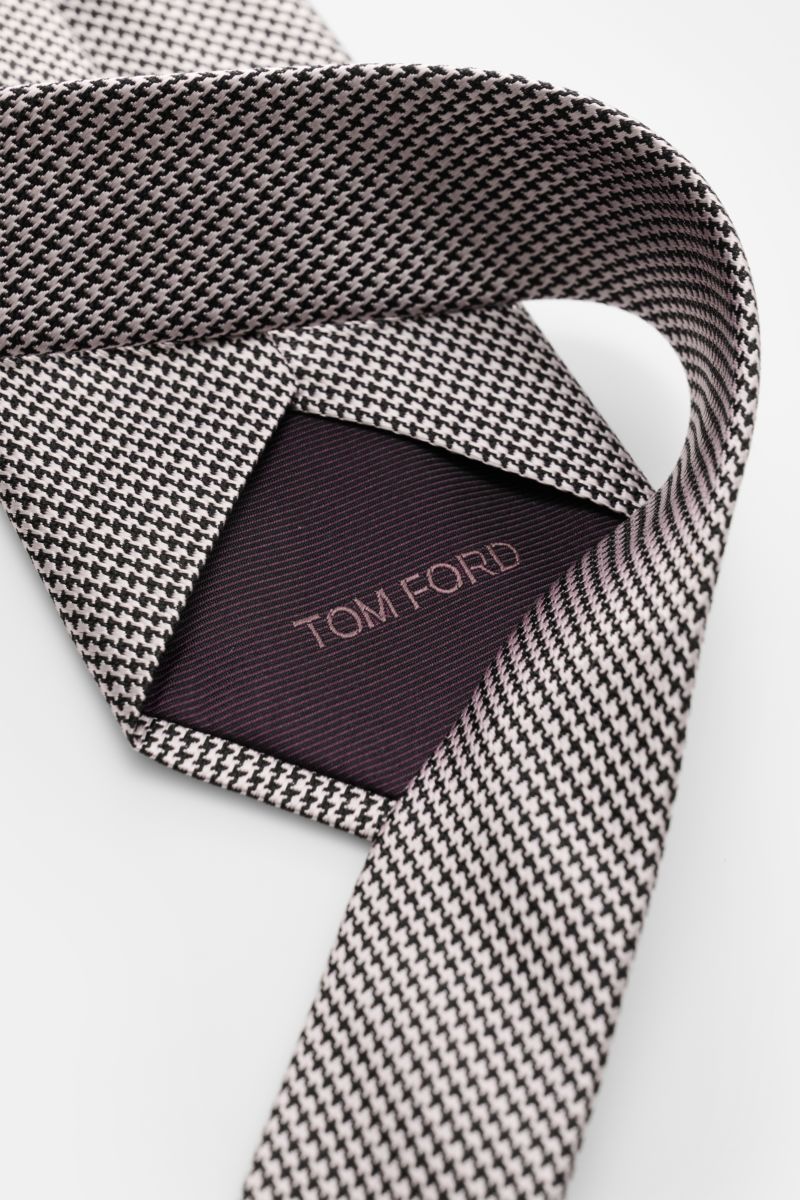 Tom Ford Seidenkrawatte rosé/schwarz gemustert mit zeitlosem Hahnentrittmuster, Logo-Stitching, reine Seide, dezenter Glanz, 8 cm breit, Nahaufnahme von oben.