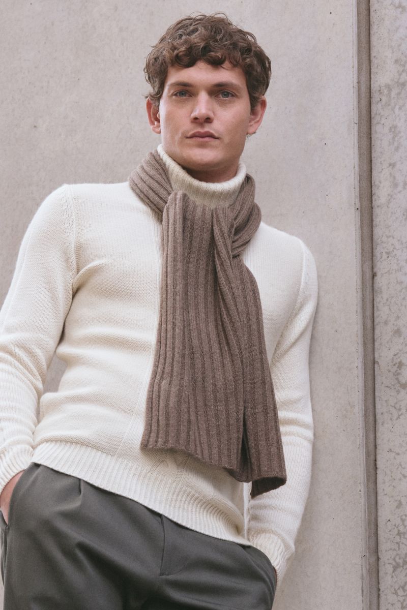Junger Mann von vorne fotografiert trägt lässig den von Braun Cashmere Schal braun meliert im klassischen Rippstrick aus reinem mongolischem Cashmere.