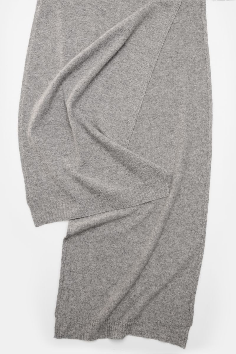 Top-down view of the 04651/ A trip in a bag Cashmere Schal creme, a soft pure cashmere scarf with rib-knit edges, measuring approx. 162 cm x 34 cm, part of the 'Look of the Games' Capsule inspired by the 2026 Olympics, offering luxurious warmth and comfor