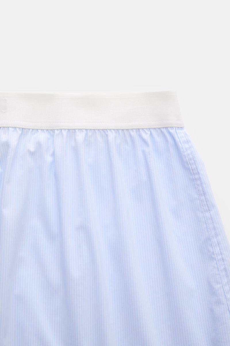 Close-up front view of Tom Ford Boxershorts hellblau/weiß gestreift featuring a slim fit, fine blue and white stripes, elastic white waistband with TOM FORD logo, and side opening. Sportlich, clean und luxuriös: Diese Boxershorts präsentieren sich im fein