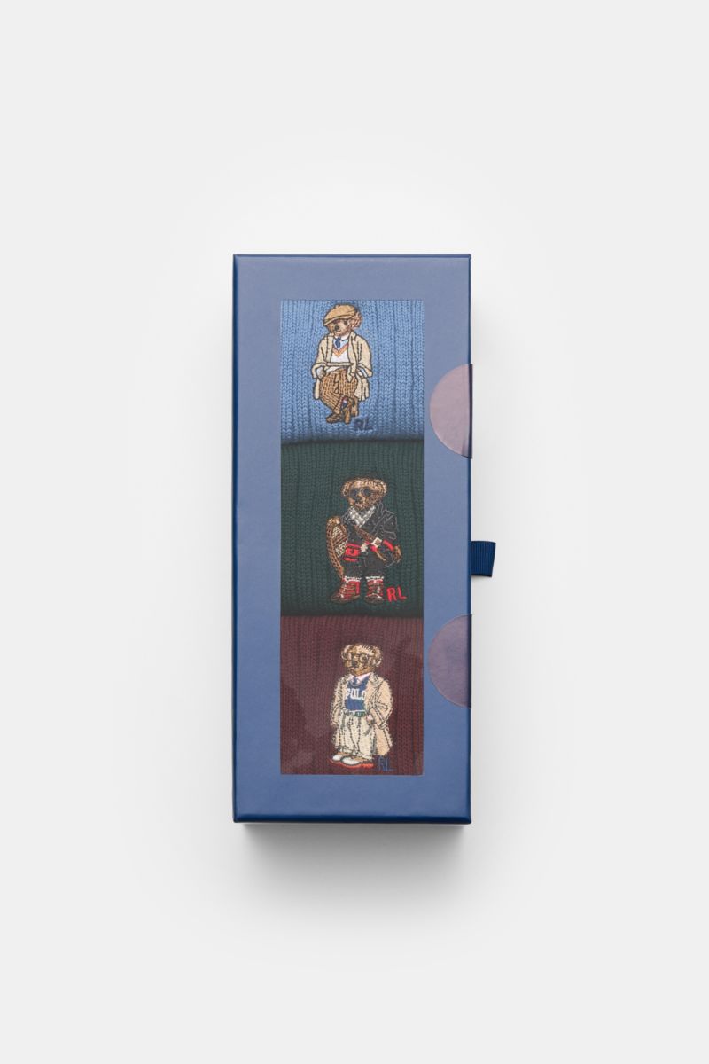 Polo Ralph Lauren Strümpfe 3er-Set grün/navy/rot shown from top-down perspective in blue box with clear window, featuring socks in blue, green, and burgundy with embroidered Teddy designs. Stylishe Statements für die kalte Jahreszeit: Die Strümpfe mit 