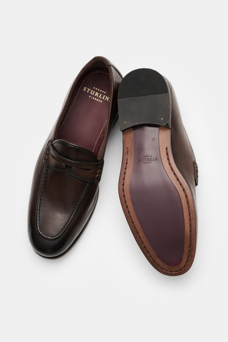 Sturlini Penny Loafer 'Bufalo' dunkelbraun aus edlem Glattleder mit Vintage-Finish, schmaler Silhouette, Penny Strap, Steppnaht, Laufsohle aus Leder und Gummi, frontal und von unten fotografiert.