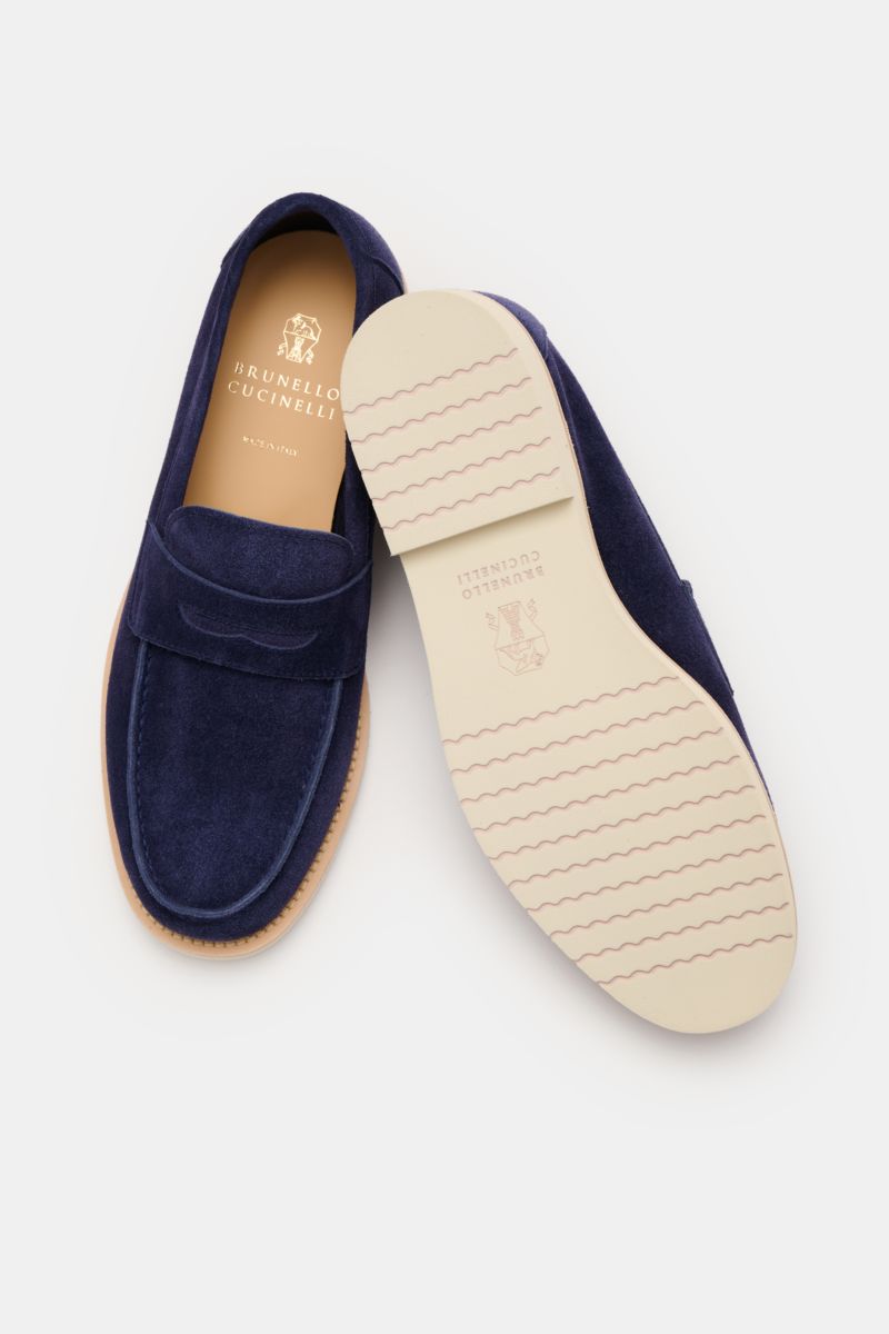 Brunello Cucinelli Penny Loafer dunkelblau shown from above and side, made of smooth dark blue suede with penny strap, light sole, and rubber outsole.