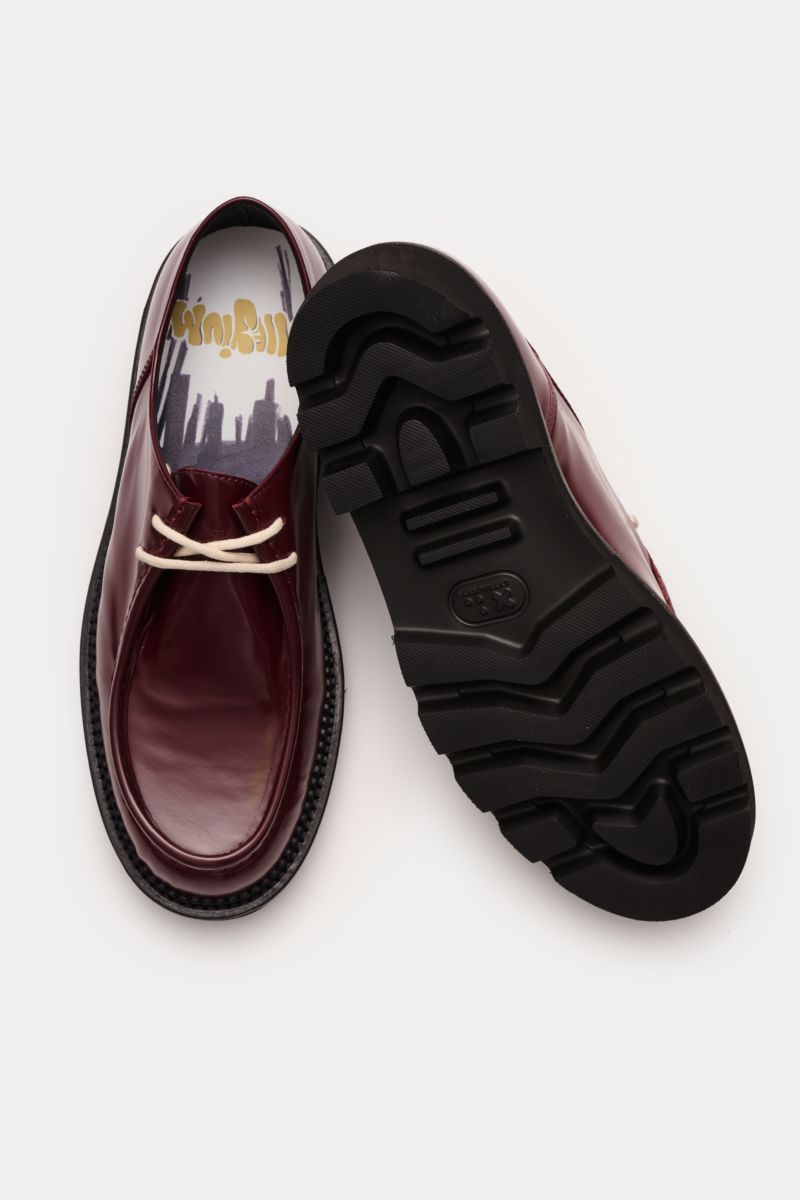 Top view of Collegium Derby 'Pillar Moc-Toe' bordeaux shoes showing polished smooth leather, narrow silhouette, open two-eyelet lacing, decorative cap seam, leather lining, and black rubber lug sole. 

Eyecatcher für die Übergangszeit: Der 'Pillar Moc-